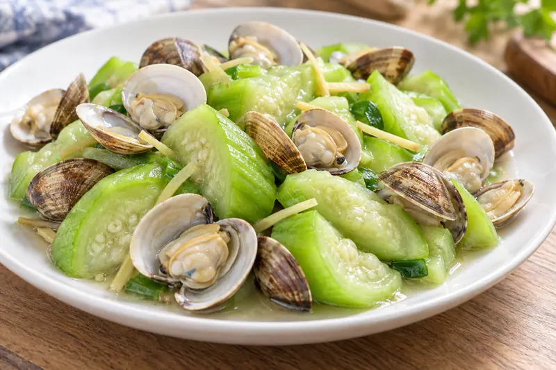 AI illustration: Opened clams stir-fried with pale-green luffa chunks.