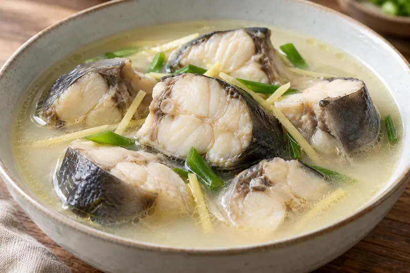 AI illustration: Tender catfish sections in a pale stock-based sauce.