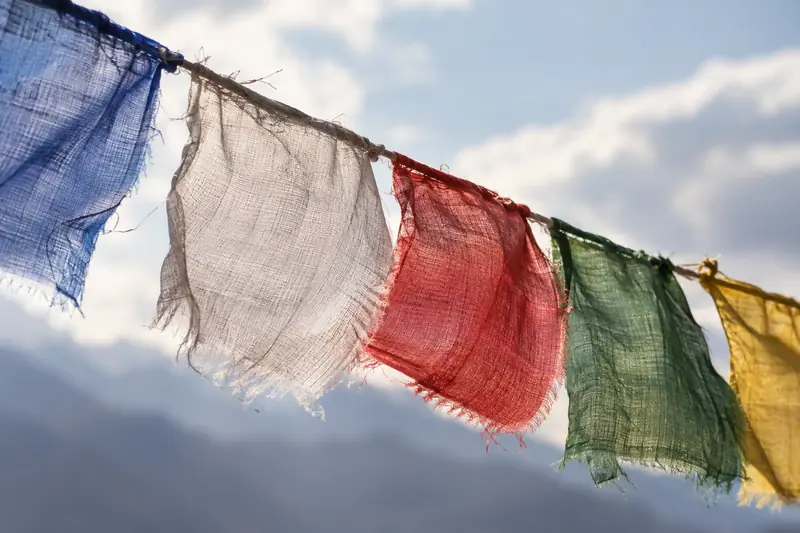 AI illustration: Woven prayer-flag cloth edges moving on a cord