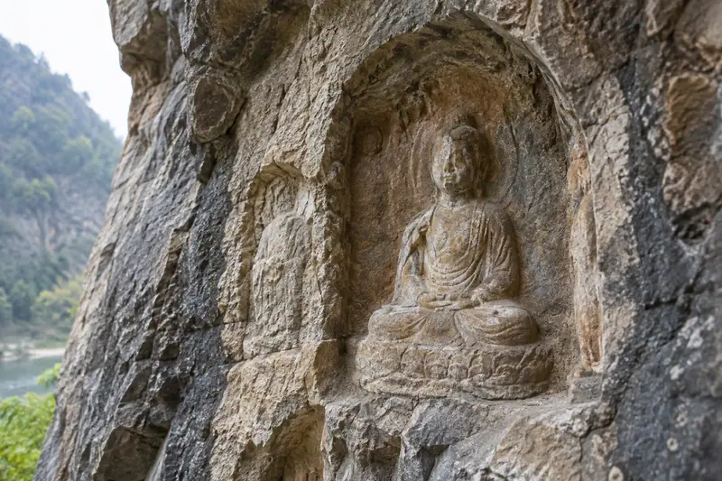 AI illustration: A close-to-medium study of a weathered Buddhist rock-cut relief niche.