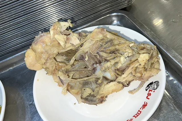 A cooked chicken frame served on a plate in Shenyang.