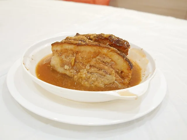 Pork belly layered with taro; the photograph does not establish the taro cultivar or growing origin.
