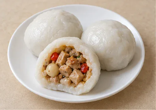 Huarong Filled Rice Dumplings (华容团子): Plump white steamed rice dumplings, one opened to show firm tofu, pork, pale lotus seed and red chilli filling. AI dish illustration; not a restaurant photograph.