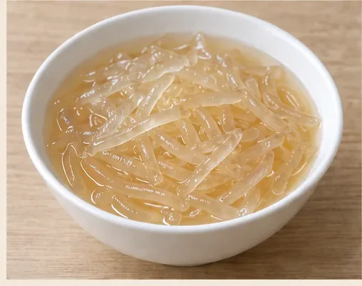Quanzhou Seaweed Jelly (石花膏): Pale amber translucent seaweed-jelly strips in clear lightly sweetened liquid, without milk or colourful mixed-dessert toppings. AI dish illustration; not a restaurant photograph.