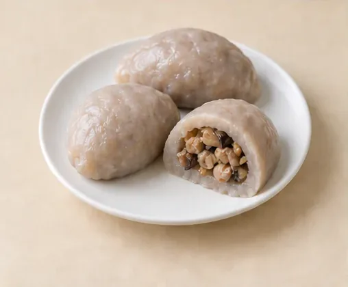 Hakka Taro Dumplings (芋子包): Smooth taro-based skin and a cut savoury filling distinguish the dumplings from pleated wheat buns. AI dish illustration.