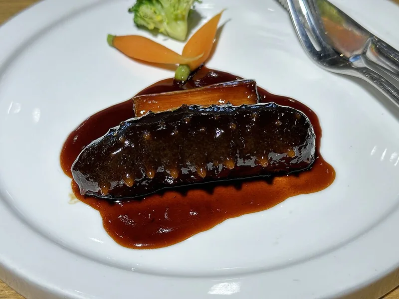 Sea cucumber braised with scallion in sauce, photographed in central Beijing in April 2024.
