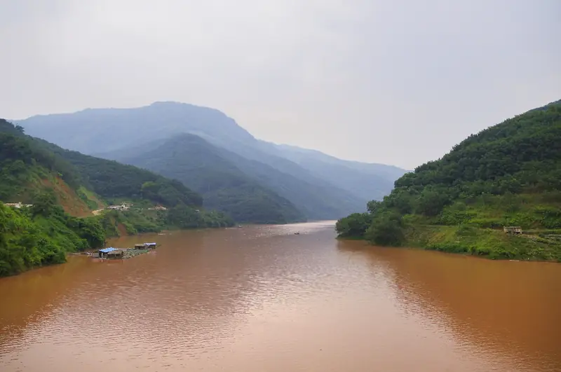 Jiangcheng Hani and Yi Autonomous County (江城哈尼族彝族自治县) — representative view · 青山夹峙的河流与沿岸树林