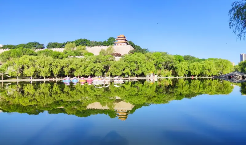 Kongtong District (崆峒区) — representative view · 湖面倒映的林木与山坡古建筑