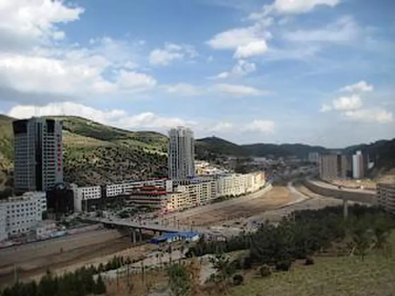 Wuqi County (吴起县) — representative view · 山谷中沿河分布的城镇建筑