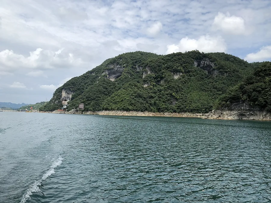 The Qing River and wooded hills in the Qingjiang Gallery scenic area of Changyang, August 2019.