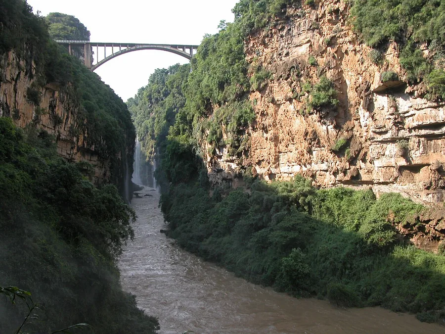 Inside Maling River Canyon, with steep walls, a waterfall and a bridge high above, July 2007.