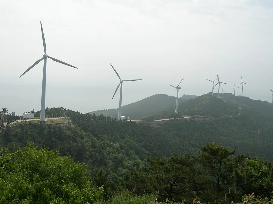 Wind turbines above wooded island hills in the Changdao archipelago; photograph date unknown.