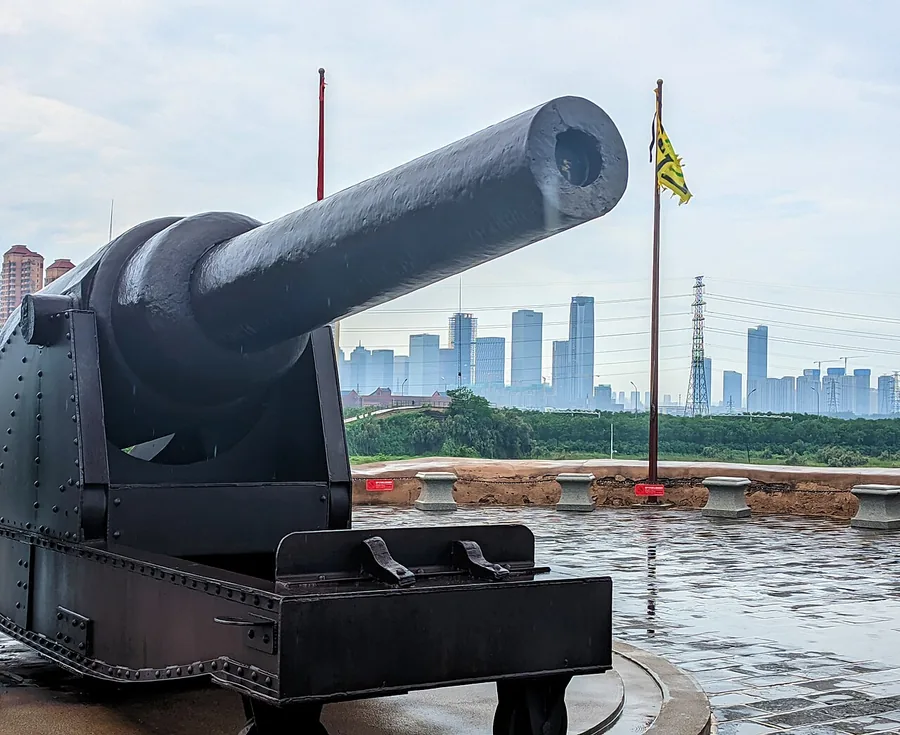 A cannon display on the Taku Forts platform, with Binhai’s modern skyline behind. Photographed on 25 August 2024.