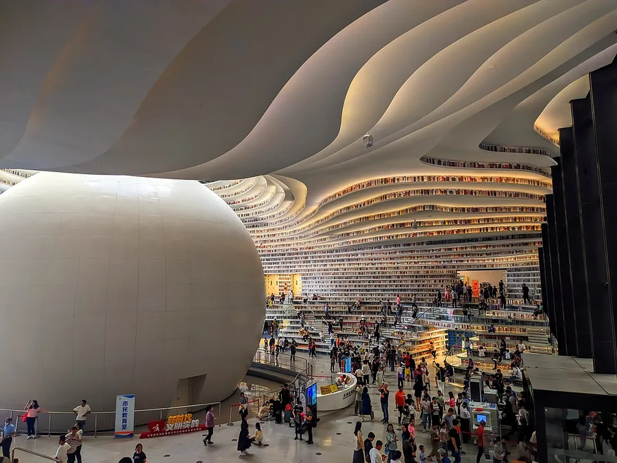 The central atrium of Tianjin Binhai Library, with its spherical auditorium and curved terraces. Photographed on 2 October 2023.