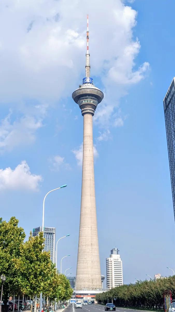 Tianjin Radio and Television Tower, seen from street level in a full-height portrait view. Photographed on 15 August 2023.