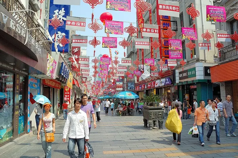 A shopping street in Wenzhou (温州), with storefronts and overhead decorations.