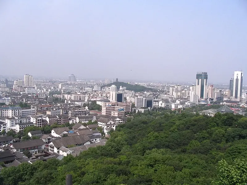 A view over Shaoxing (绍兴), with wooded parkland beside the urban neighbourhoods.