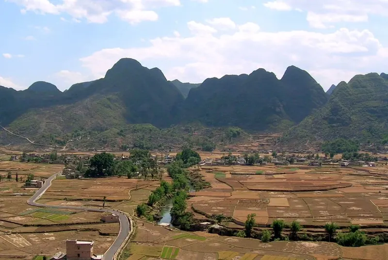 A river and fields at Wanfenglin near Xingyi (兴义万峰林), within Qianxinan Buyei and Miao Autonomous Prefecture, photographed in May 2005.