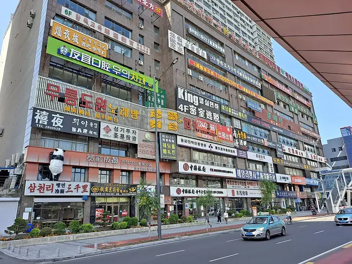 Commercial streetfront buildings beside the Gongyuan Bridge BRT stop in Yanji. Photo: 2023-06-23.