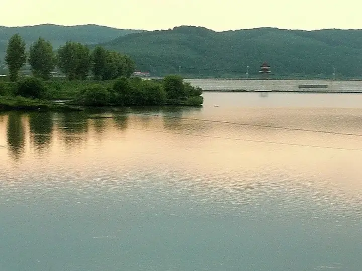 A calm reach of the Mudan River and wooded shoreline in Ning'an, Heilongjiang. Photo: Taken on 13 June 2010.