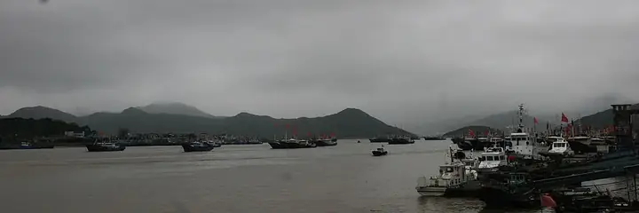 The fishing harbour, moored boats and surrounding hills at Shipu in Xiangshan County, Zhejiang.