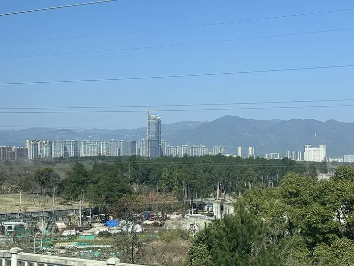 Urban buildings, woodland and distant hills in Tiantai County, Zhejiang. Photo: 2024-03-03 13:48:57.
