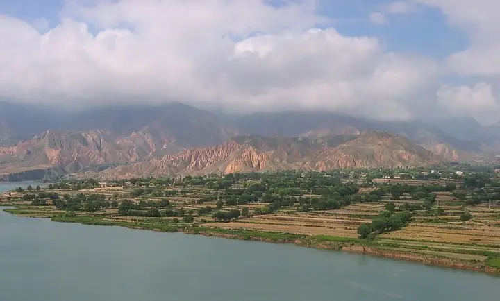 River valley with farmland below eroded mountains near Xunhua