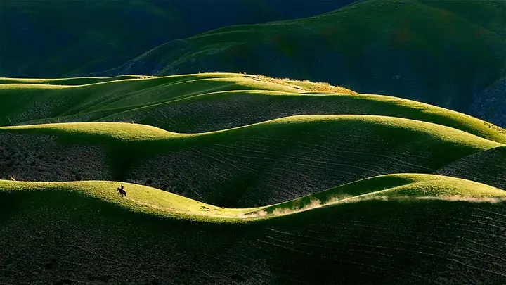 Rolling grassland lit by low evening sun in Tekes County, Xinjiang. Photo: before 15 August 2016, 14:10:37 (UTC).
