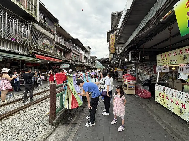 Railway and shops along Shifen Old Street · 十分老街铁道与两侧店铺. Shown locality: Pingxi and Shifen Old Streets, Pingxi District. Source-recorded photograph date: 2025-04-19 11:01:55.