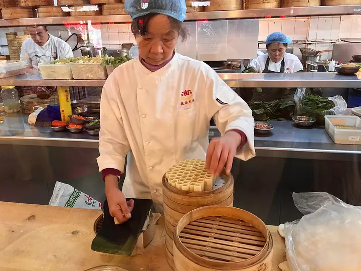 Preparing youmian wowo oat-flour rolls in a bamboo steamer in Hohhot.