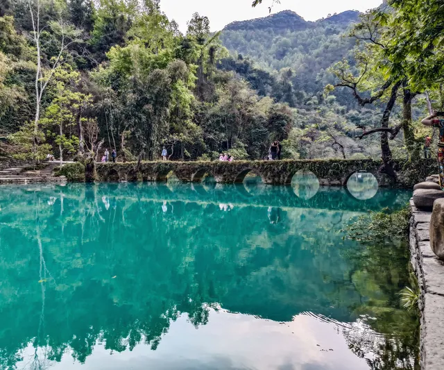 The seven-arch stone bridge and green river in Xiaoqikong Scenic Area, Libo · 荔波小七孔古桥与河水