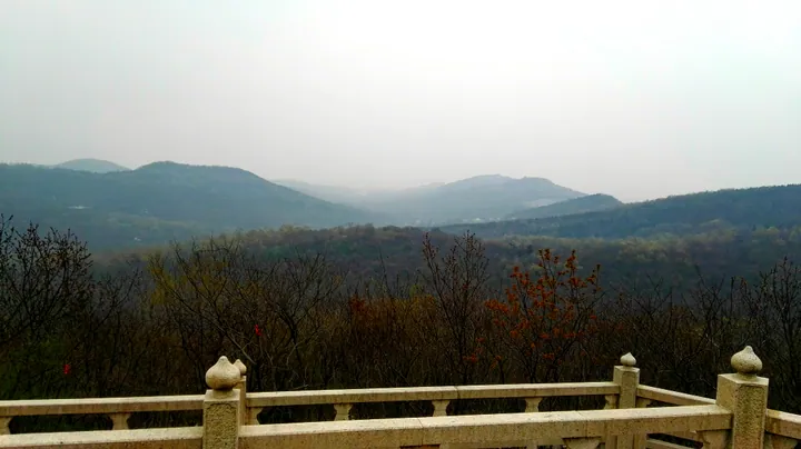 Hazy mountain ridgeline viewed from a stone-railed overlook at Bagong Mountain