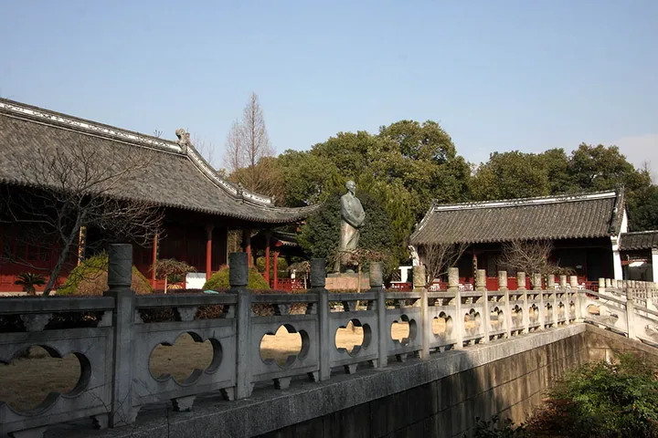 Memorial hall courtyard with a bronze statue of Wu Jingzi flanked by traditional halls