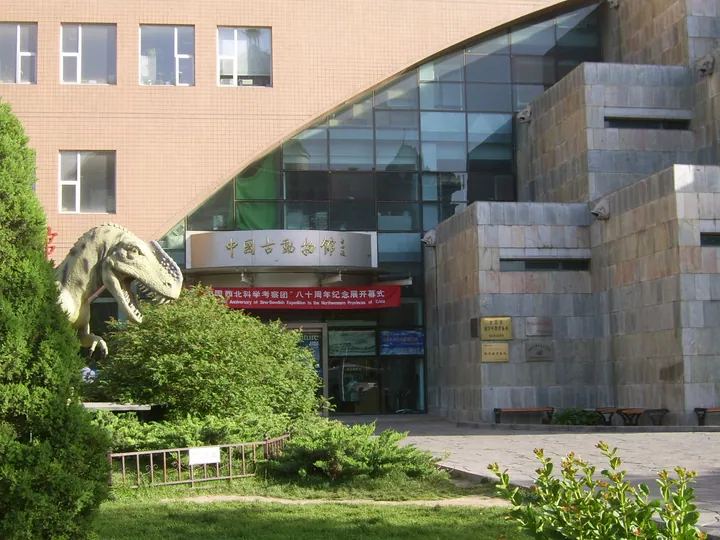 Museum entrance building with a large dinosaur statue and the museum's Chinese-name signage