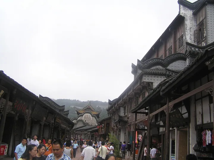 Crowded street with traditional wooden shopfronts in Luodai Ancient Town