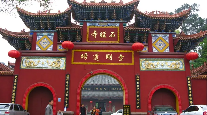 Red temple gateway inscribed Shijing Temple with lanterns and a central arch