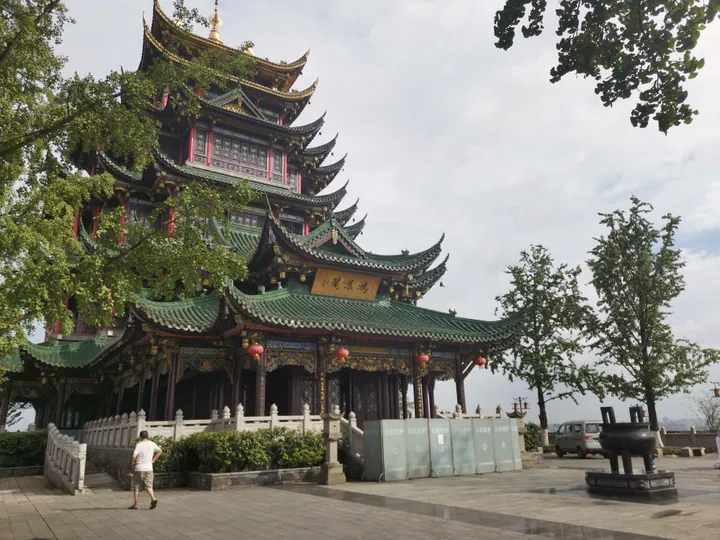 Tall green-roofed seven-storey Chinese pagoda with red lanterns, viewed from below.