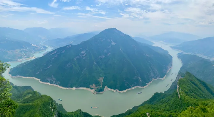 Sweeping aerial view of a river gorge winding between steep green mountains