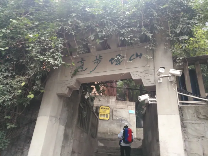 A vine-covered stone archway inscribed with the trail's name over a stairway