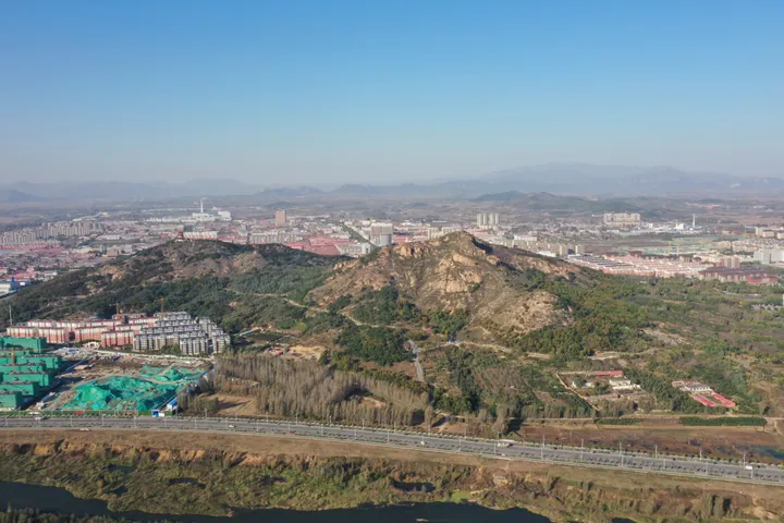 Aerial view of Funing District's skyline with a hill and river in the foreground