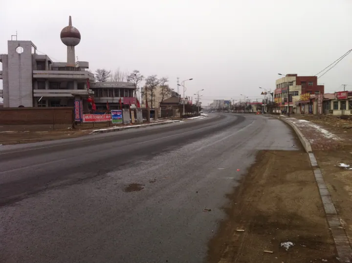 Street scene in Lulong County with shops and a sphere-topped tower building