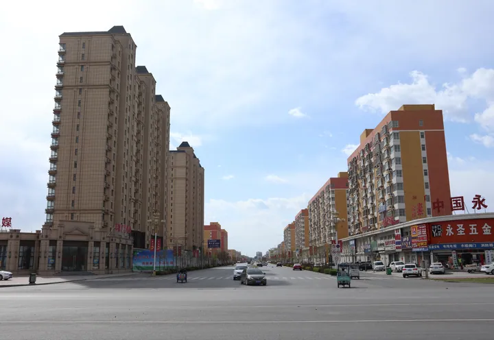A wide city street with modern residential towers, Rongcheng County