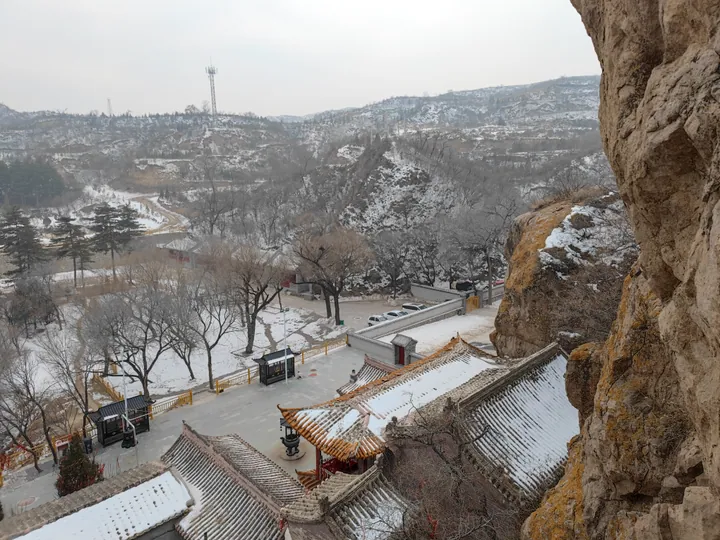 Snow-covered temple roofs and cliffside overlook in Xuanhua