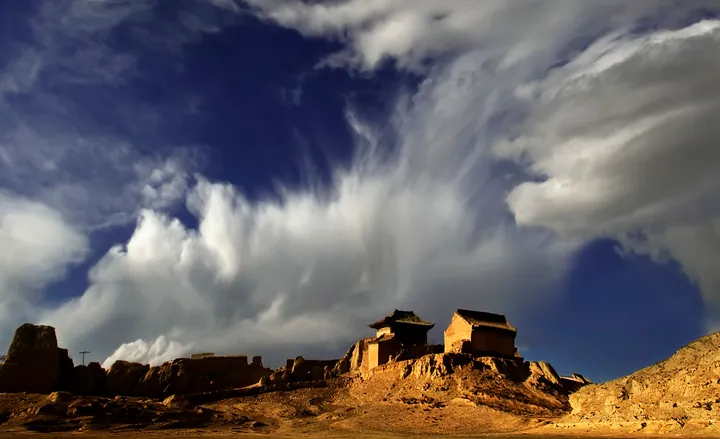 Ancient fort ruins on a cliff top under a dramatic cloudy sky