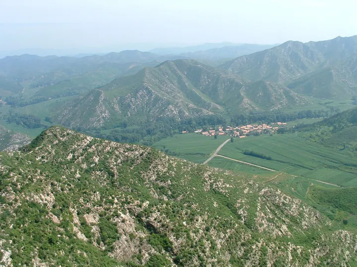 A green mountain valley with a small village, seen from above