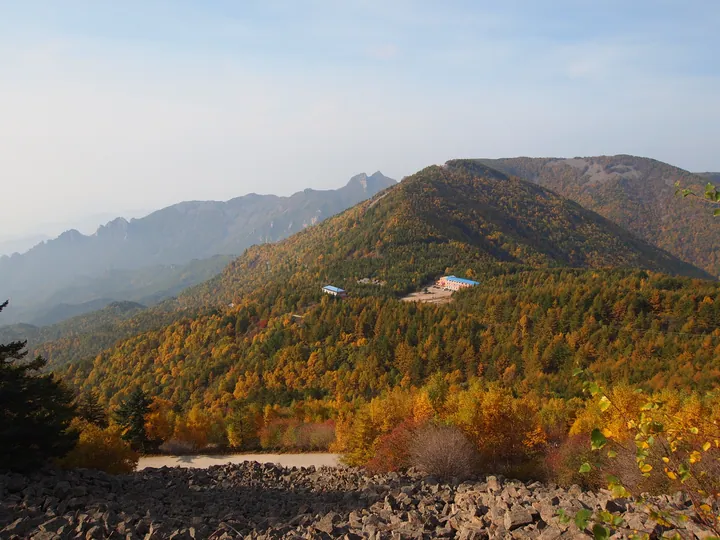 A panoramic mountain valley view with layered ridges in autumn colour