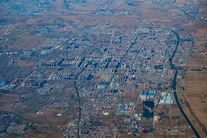 Aerial view of a grid-planned town with a river running through it in Xian County