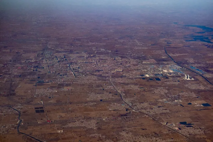 Aerial view of a city with tall buildings and roads in Renqiu