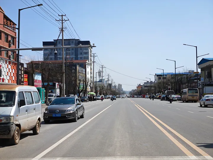 A street scene along the S220 highway with shops and traffic, Qin County