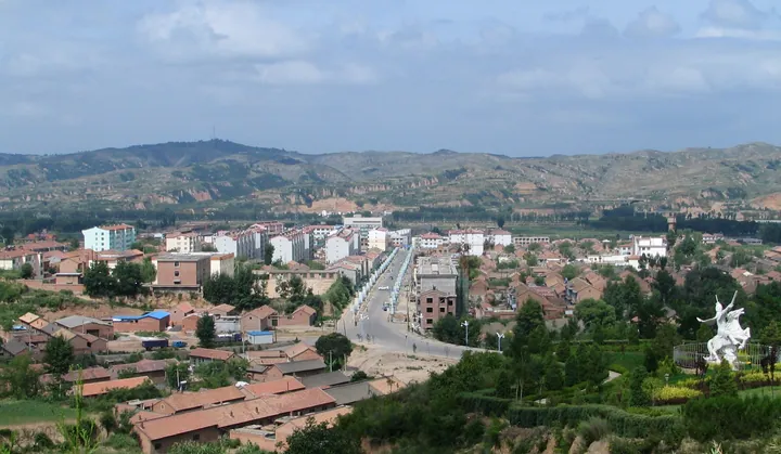 An elevated view of Yushe County's town centre from a pagoda, with hills behind
